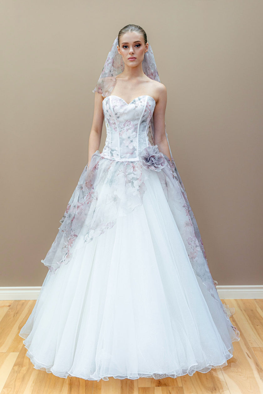 Romantic floral couture wedding gown with a structured corset bodice, layered tulle ball gown skirt, and matching floral cathedral veil.