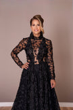 Refined black couture dress with floral appliqué details and sheer long sleeves