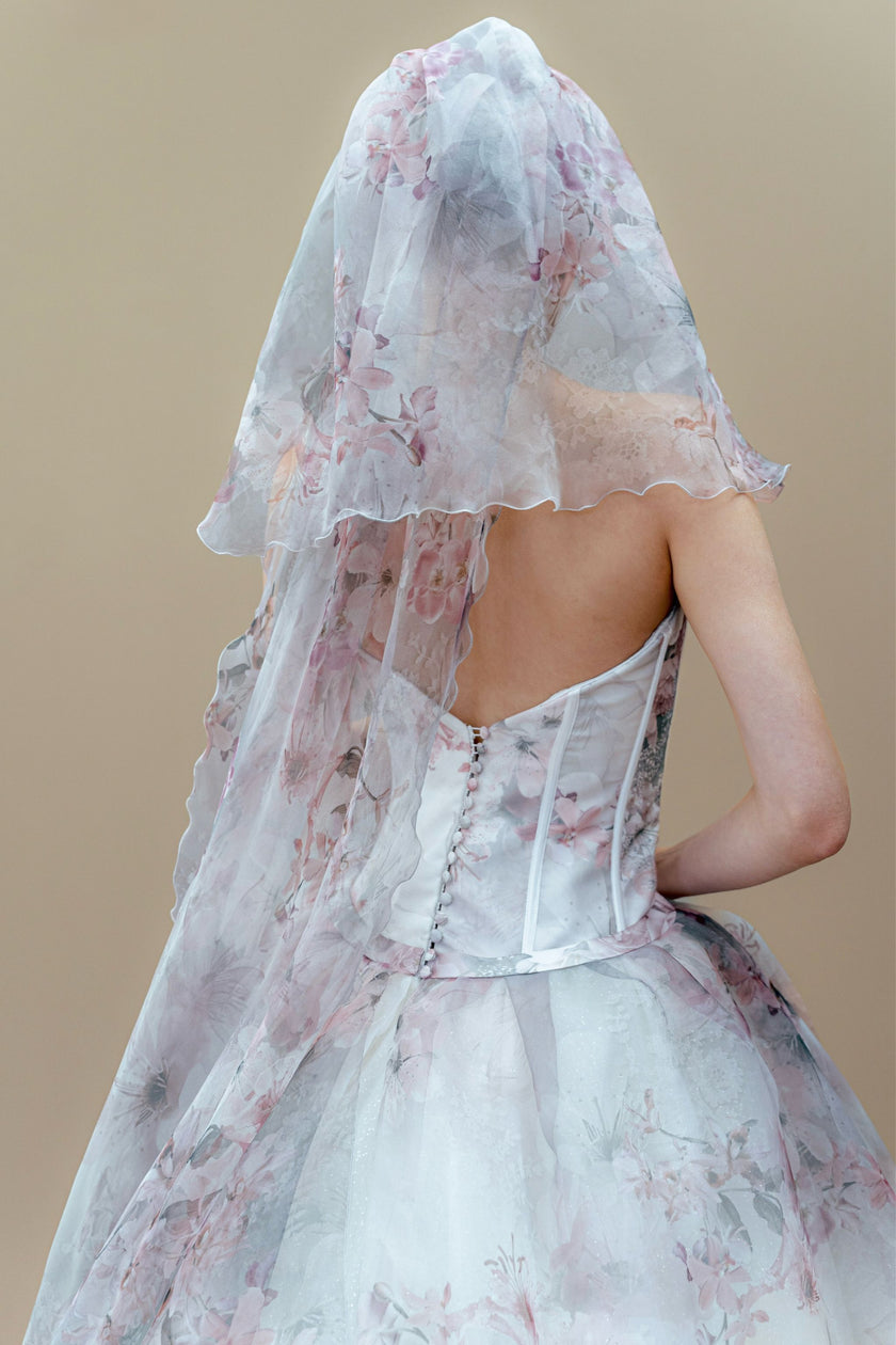 Back view of the floral couture wedding gown with corset back and matching veil.