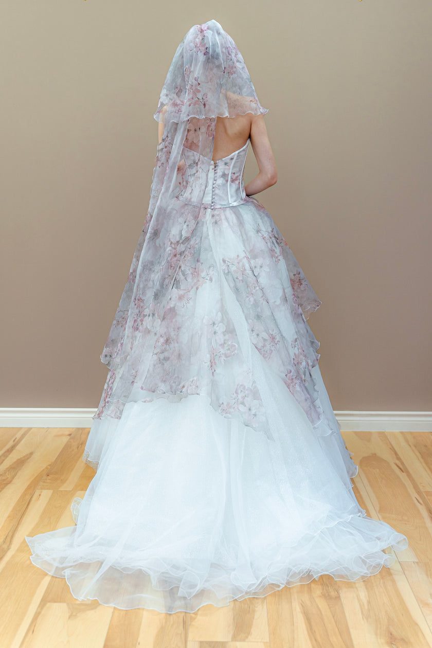 Back view of the romantic floral couture wedding gown, showcasing the structured corset bodice, detailed lace-up closure, and the full layered tulle ball gown skirt.