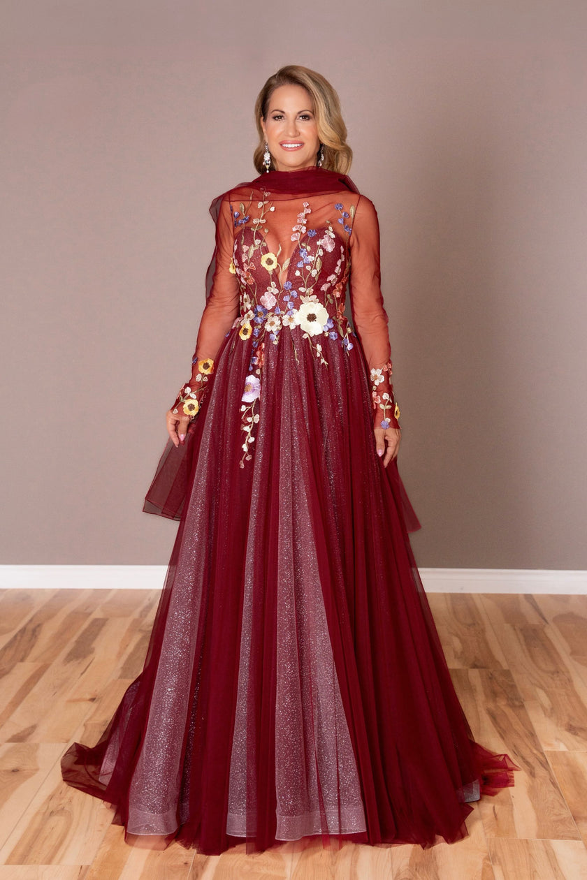 Burgundy mother of the bride gown with a floral appliqué illusion bodice and sheer sleeves.
