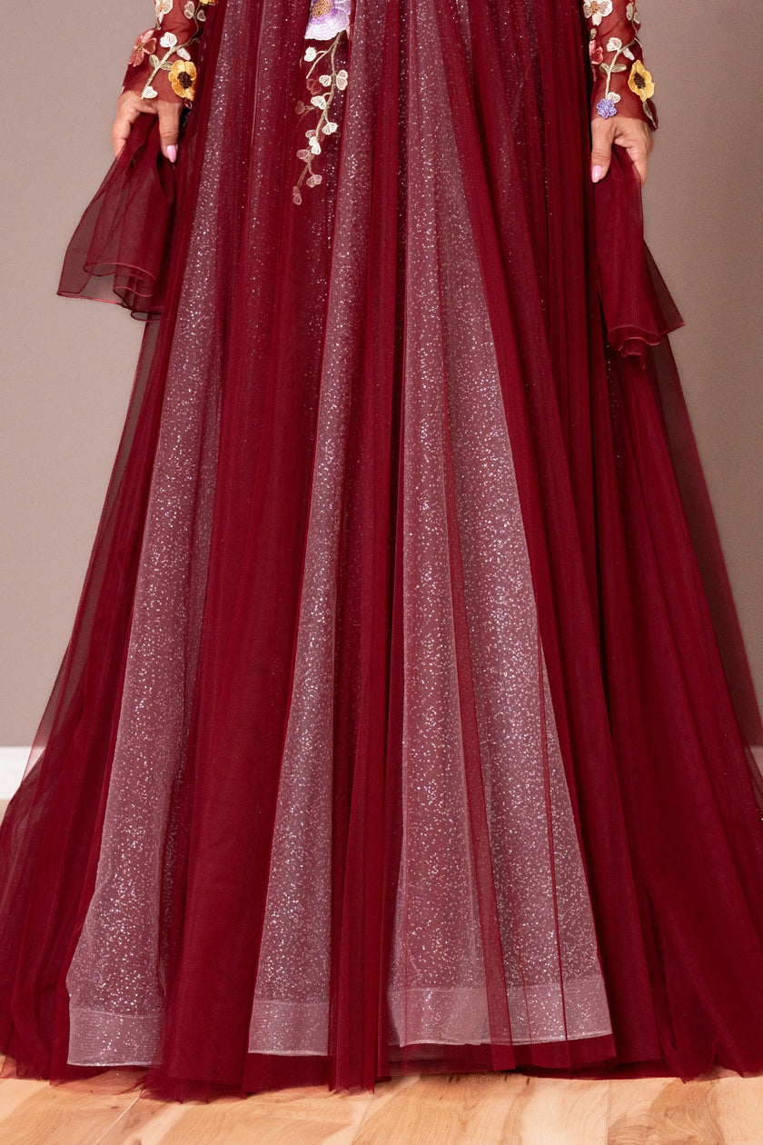 Sheer long sleeve with floral detailing on a burgundy A-line gown.