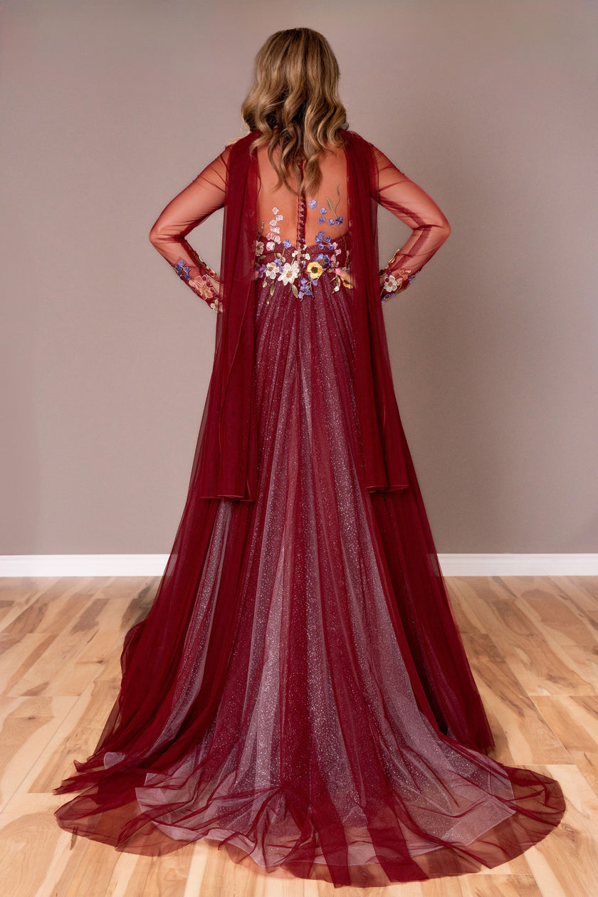 Back view of the burgundy A-line gown with floral appliqué, showcasing the floor-length skirt.