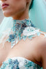 Close-up of aqua wedding gown illusion high-neck bodice with intricate floral embroidery and beadwork.