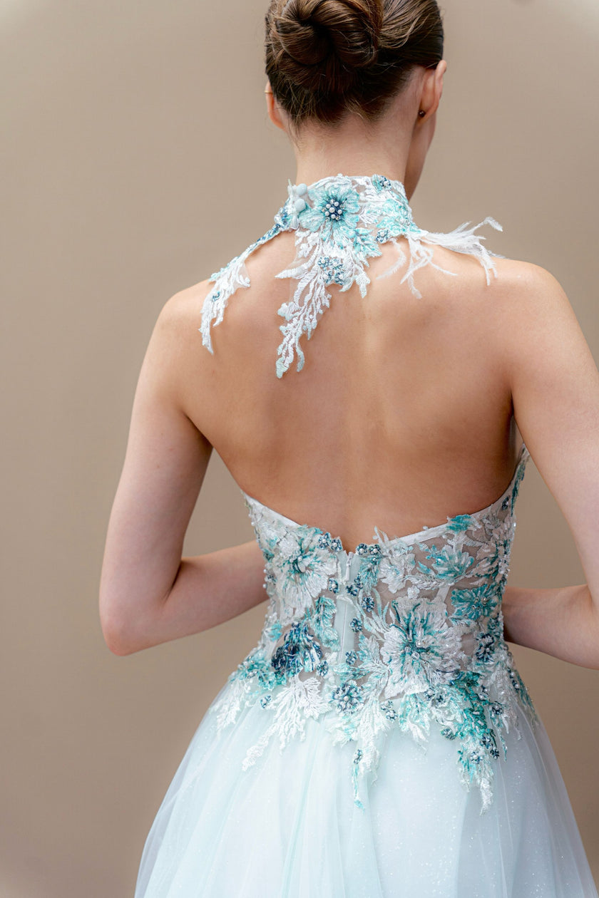 Close back view of the aqua wedding gown, capturing the delicate embroidery on the illusion back.
