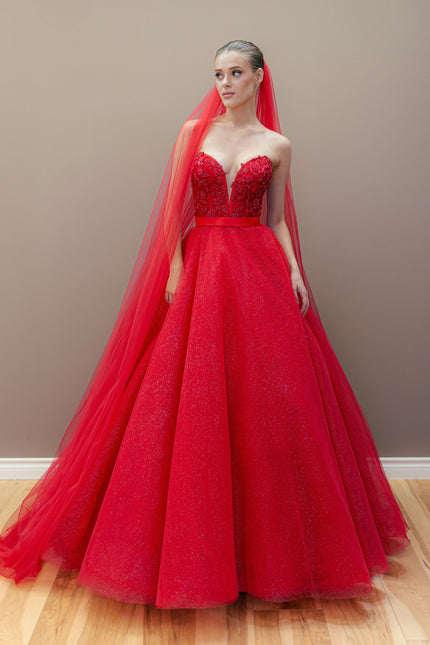 Red couture ball gown with an embroidered sweetheart bodice and a voluminous, shimmering tulle skirt.