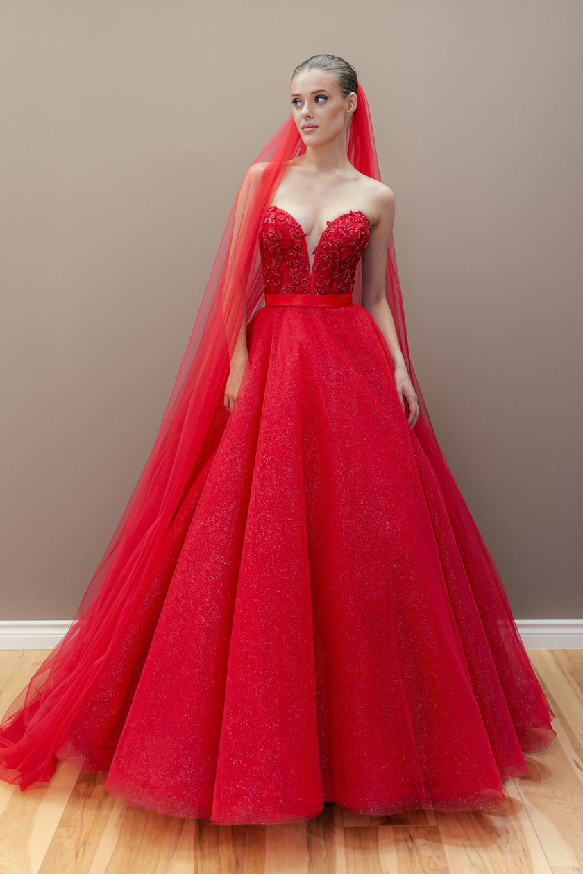 Red couture ball gown with an embroidered sweetheart bodice and a voluminous, shimmering tulle skirt.