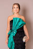 Black fringe gown with sheer long sleeves and a dramatic emerald satin bow.