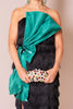 Woman wearing a black dress with a large teal bow and holding a colorful clutch.