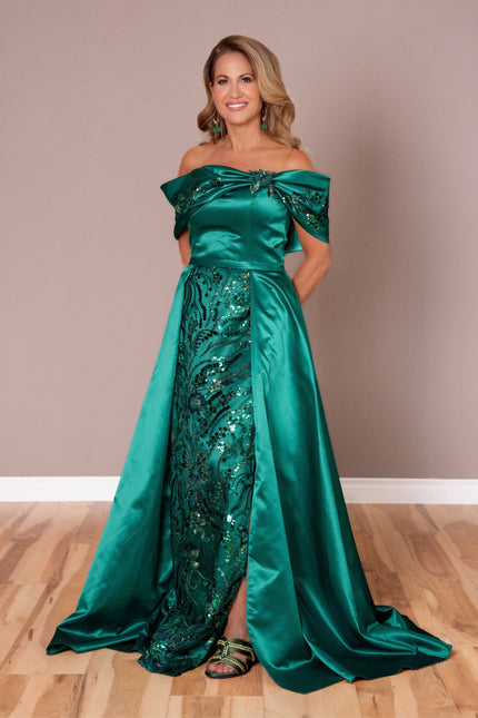 Emerald green off-the-shoulder gown with a structured satin overskirt and shimmering sequin underlay.