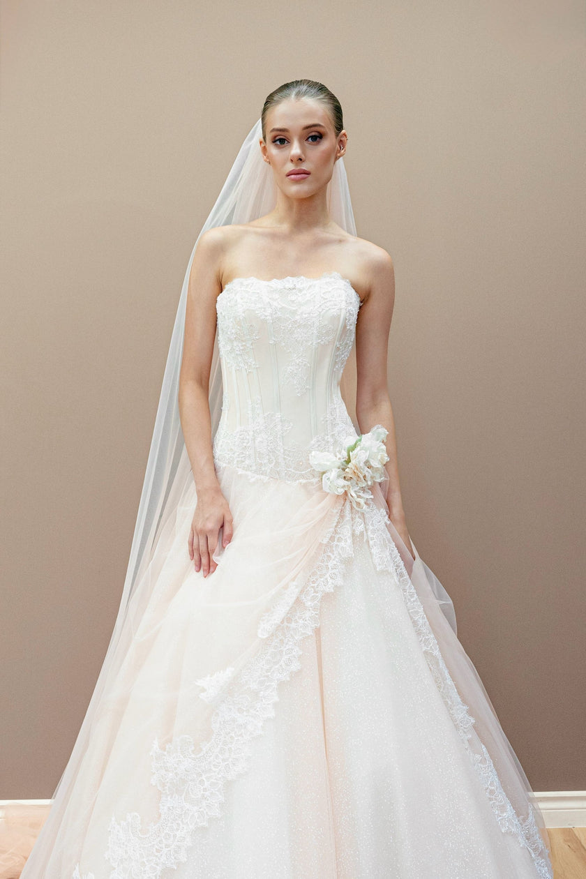 Peach bridal gown with lace corset, embroidered floral appliqué, and cathedral veil.