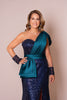 Woman wearing a blue sequin dress with a green draped over-shoulder detail.