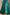 Elegant high slit on the emerald green satin gown, perfect for movement at formal events.
