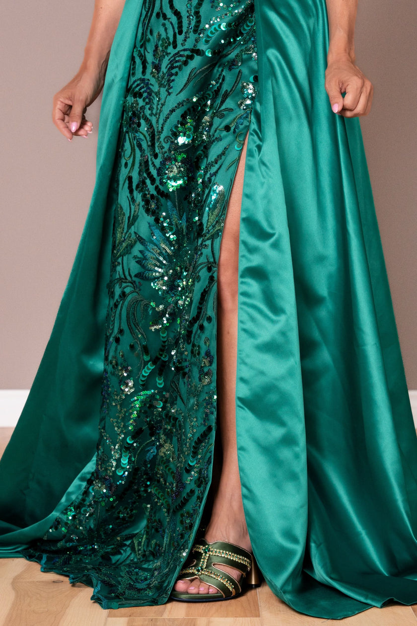 Elegant high slit on the emerald green satin gown, perfect for movement at formal events.