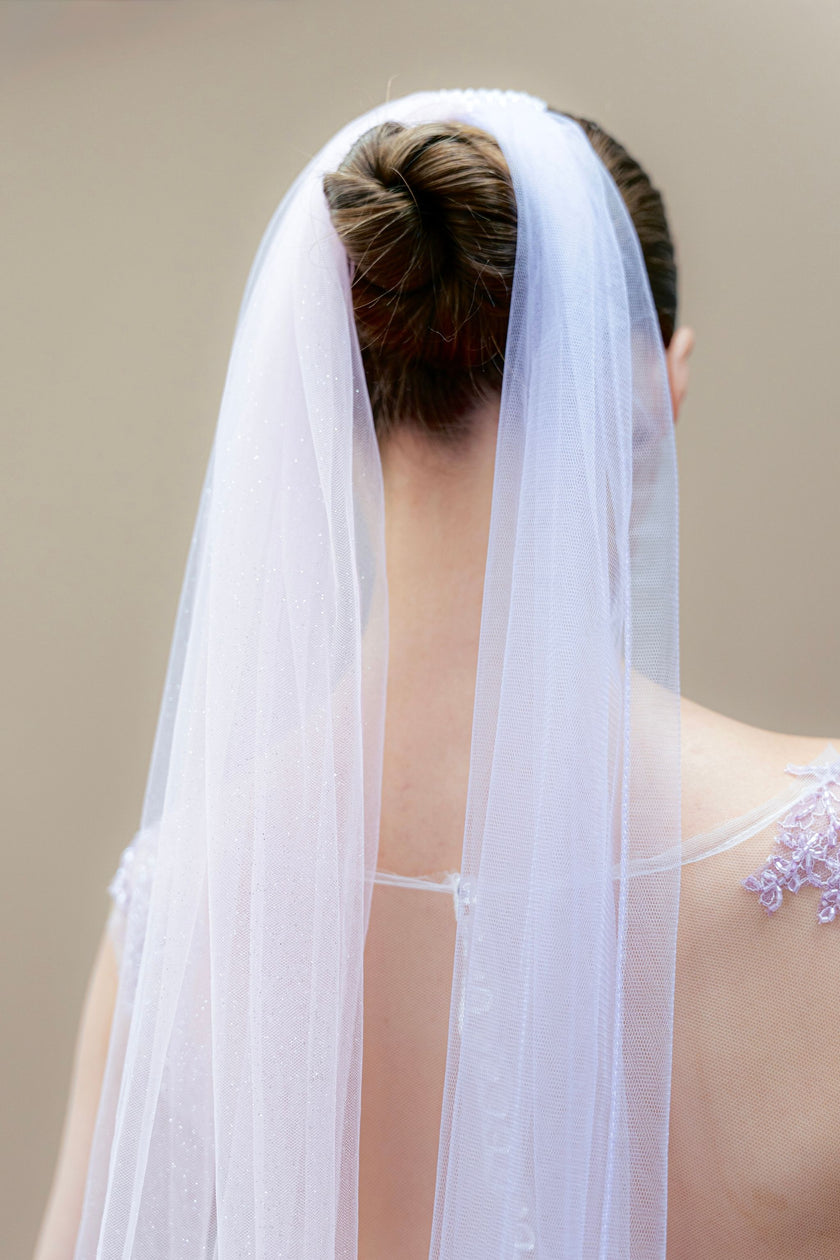 Back view of couture wedding gown with lavender lace and two-tone veil.