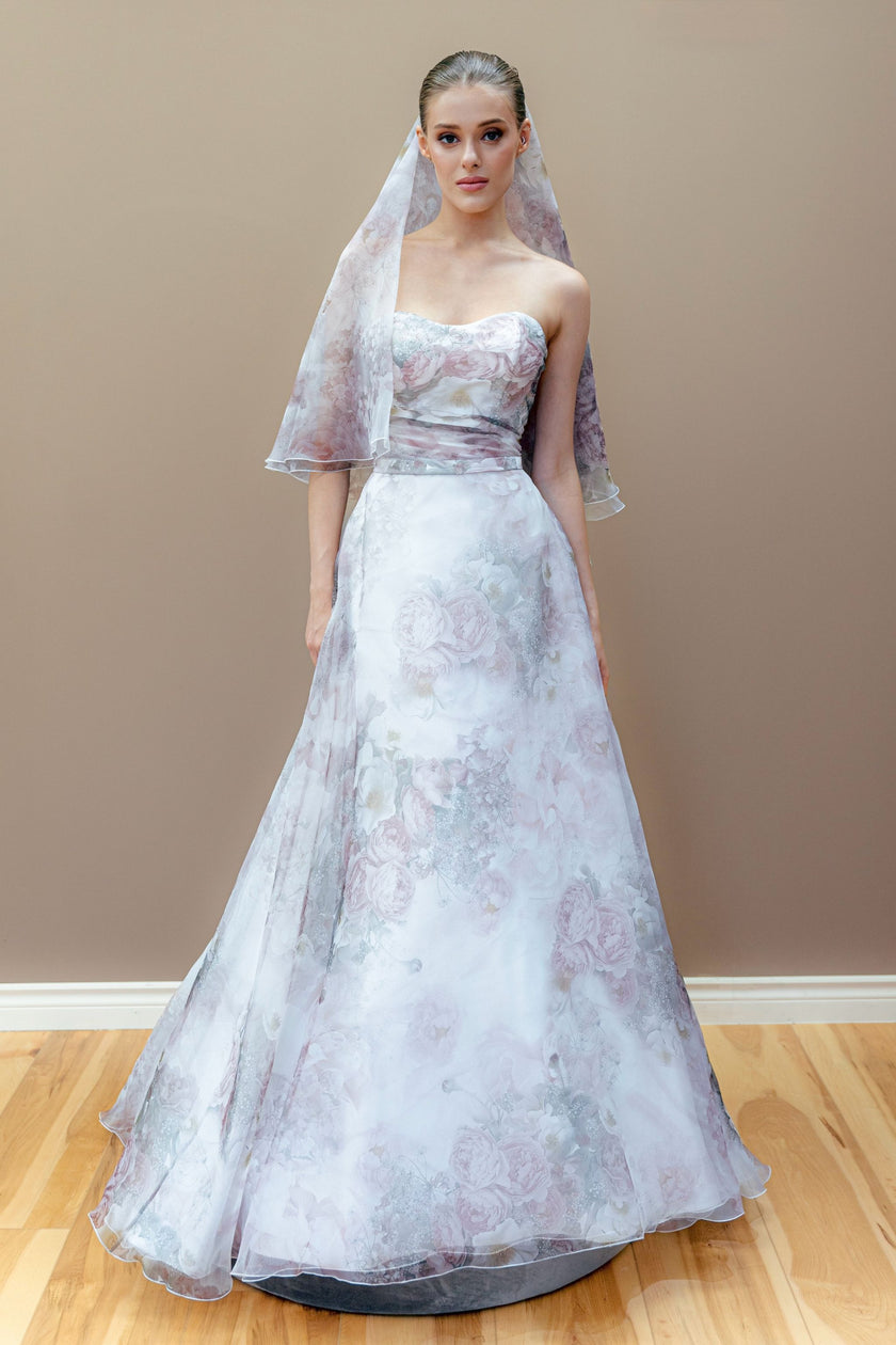 Strapless floral couture wedding gown with a draped bodice and pastel A-line skirt, featuring a matching pastel floral veil.