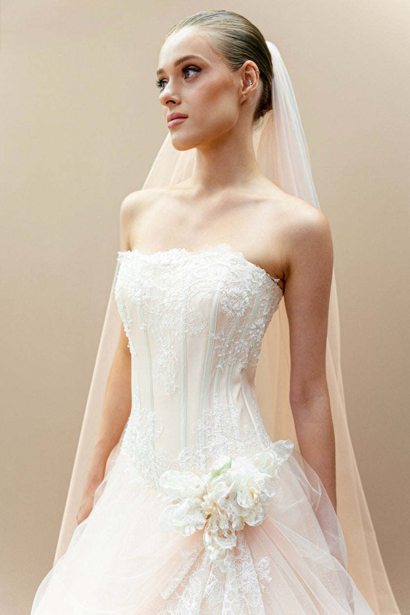 Front view of peach wedding gown with lace corset and floral appliqué.