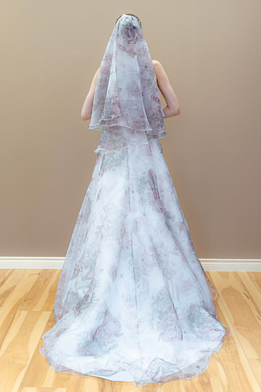 Back view of a strapless floral A-line wedding gown with a matching pastel floral veil.