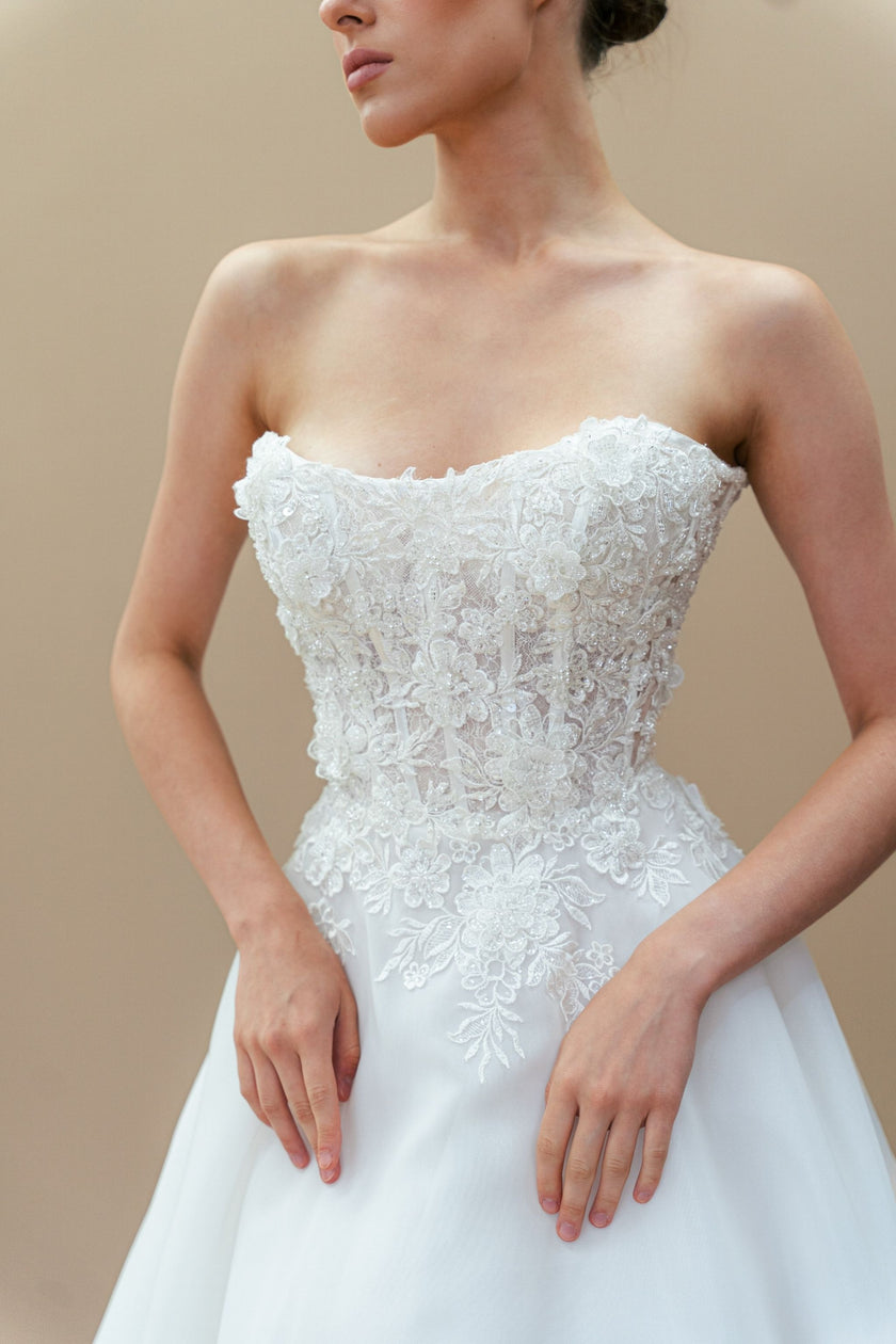 Close-up of Swarovski crystals on strapless lace corset wedding dress.
