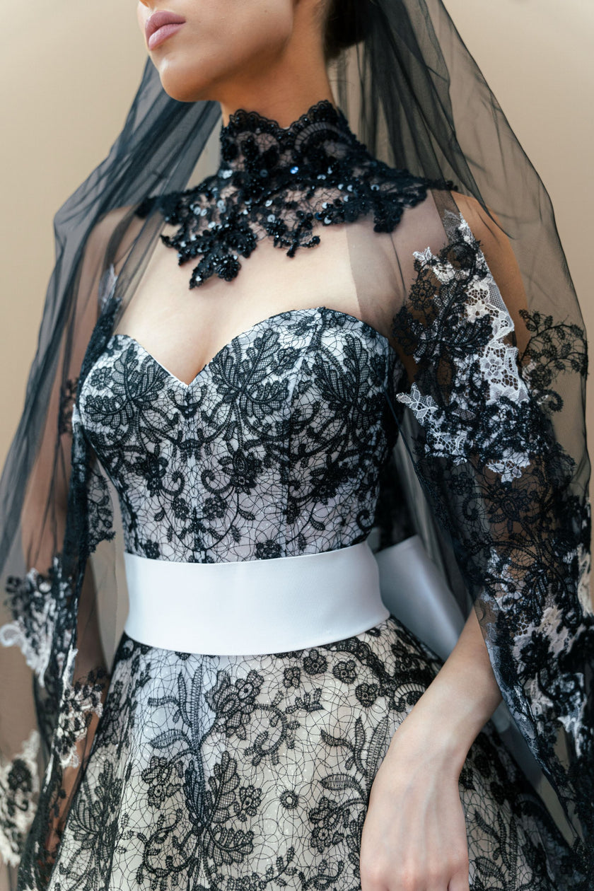 Close-up of the black lace embroidery on the strapless sweetheart bodice of the couture gown.