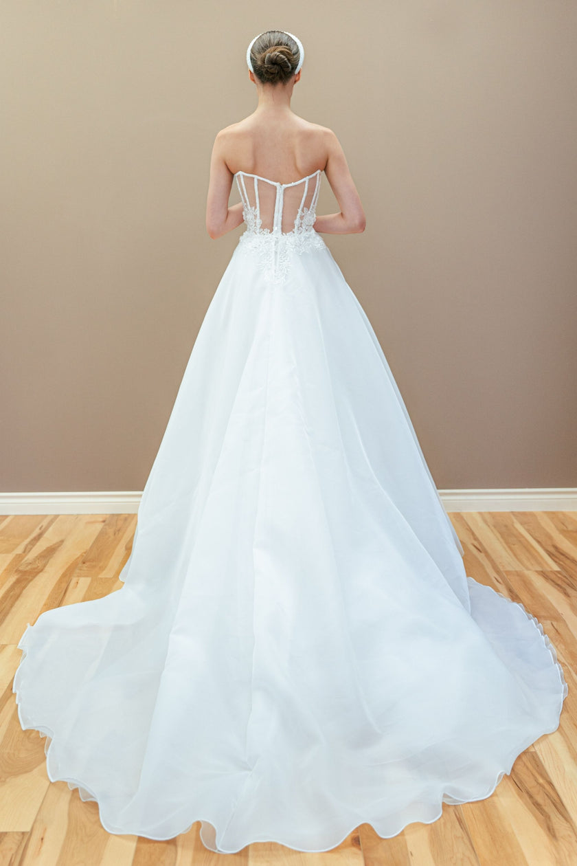 Elegant back of the couture strapless wedding gown, showcasing the structured corset and skirt with a long train.