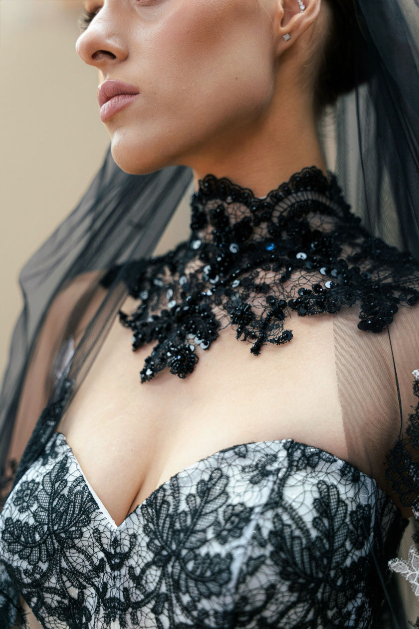Close-up of the black lace embroidery and sequin detailing on the couture wedding gown's bodice.