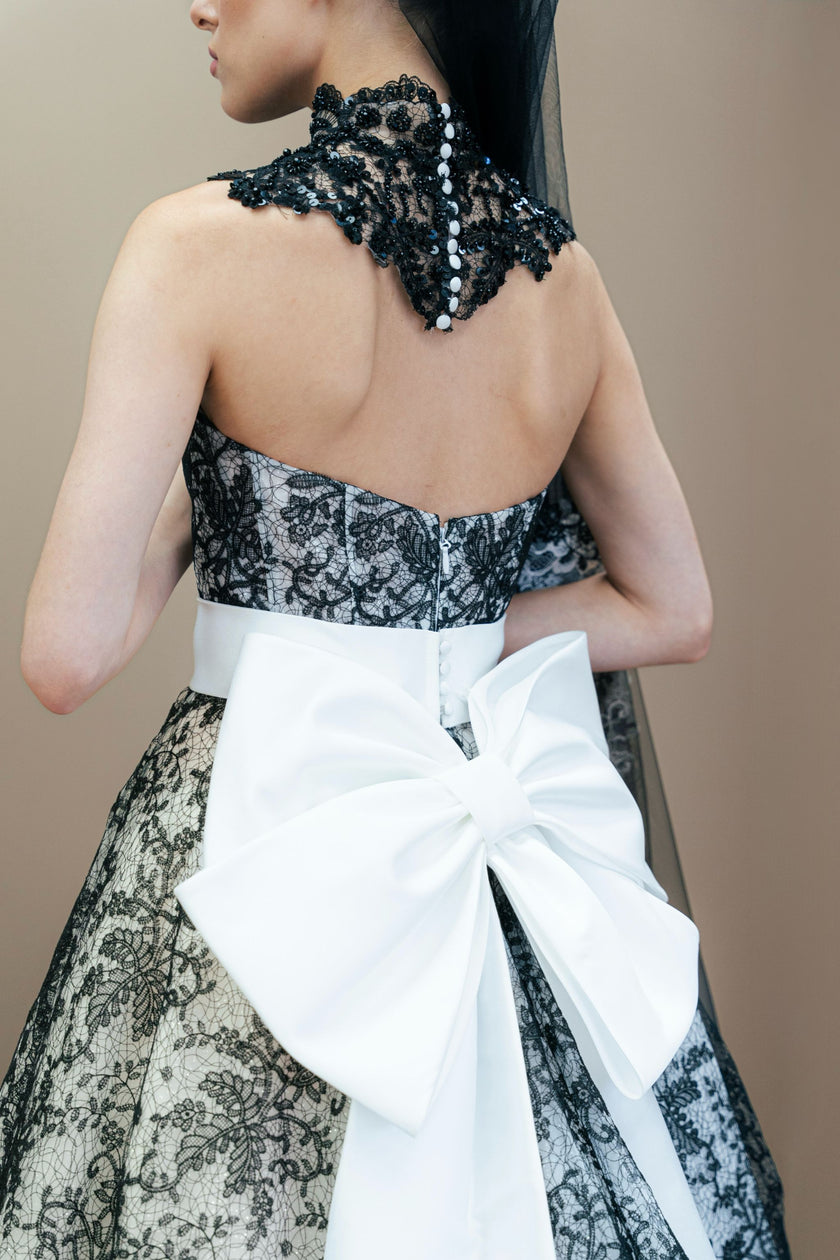 Black and white couture wedding gown with a dramatic oversized white bow on the back.