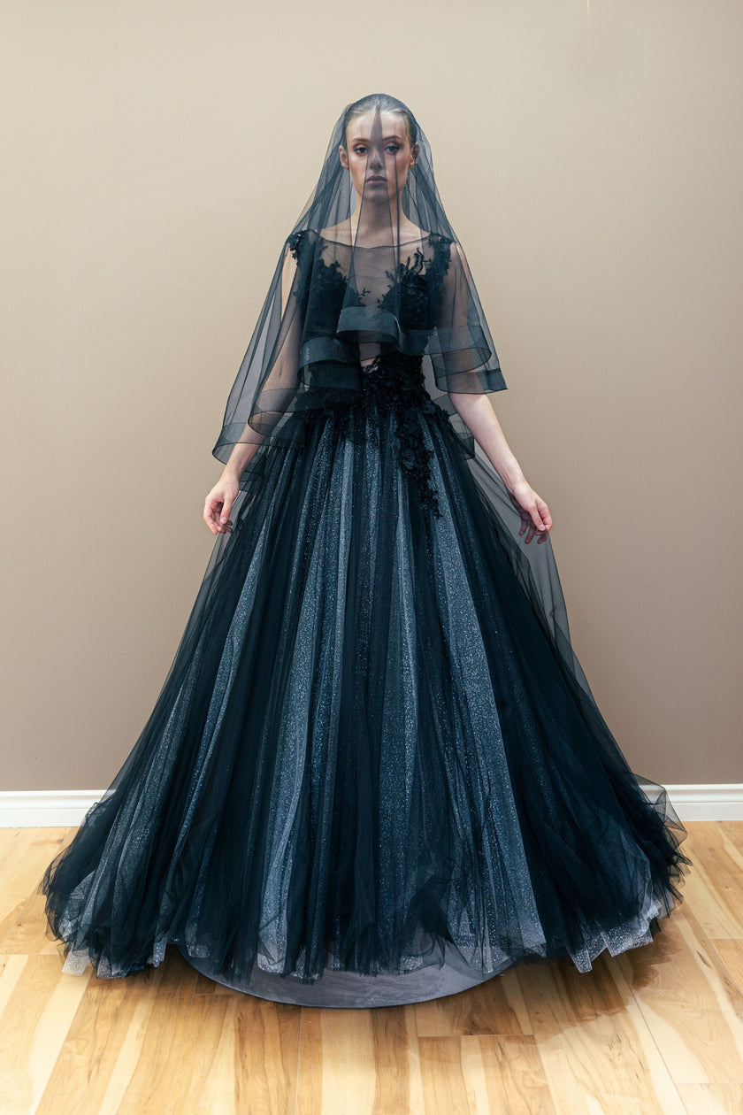 Black couture wedding gown with an embroidered illusion bodice and a voluminous, layered tulle skirt.
