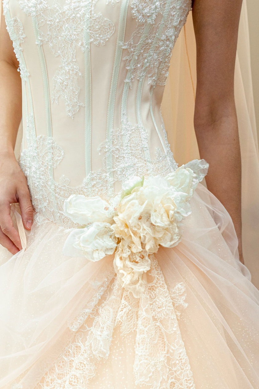 Detailed view of floral embroidery on peach bridal gown bodice.