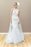 Modern couture wedding gown with a halter neckline, sheer lace bodice, and elegant fringe detailing.