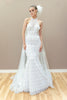 Modern couture wedding gown with a halter neckline, sheer lace bodice, and elegant fringe detailing.