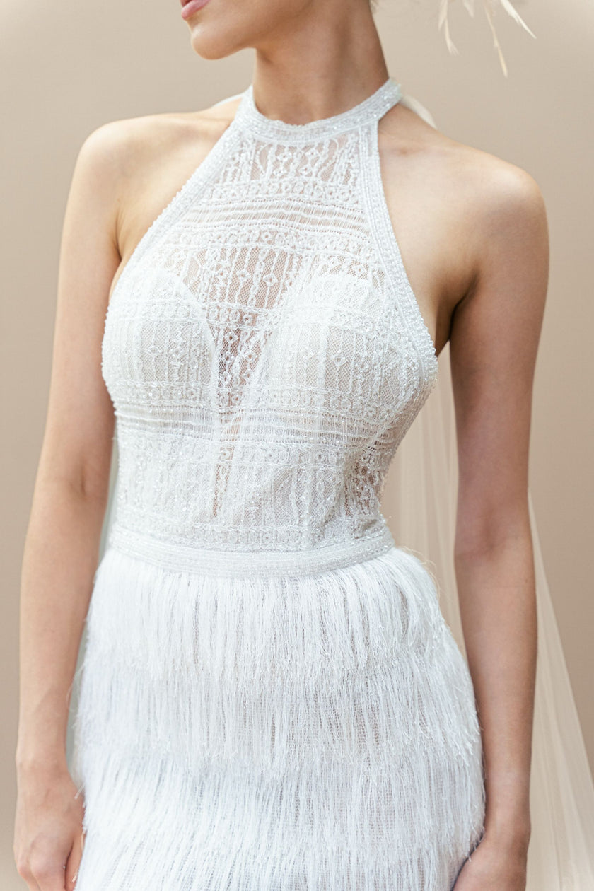 Sheer lace bodice and halter neckline on a modern, fitted couture wedding gown.