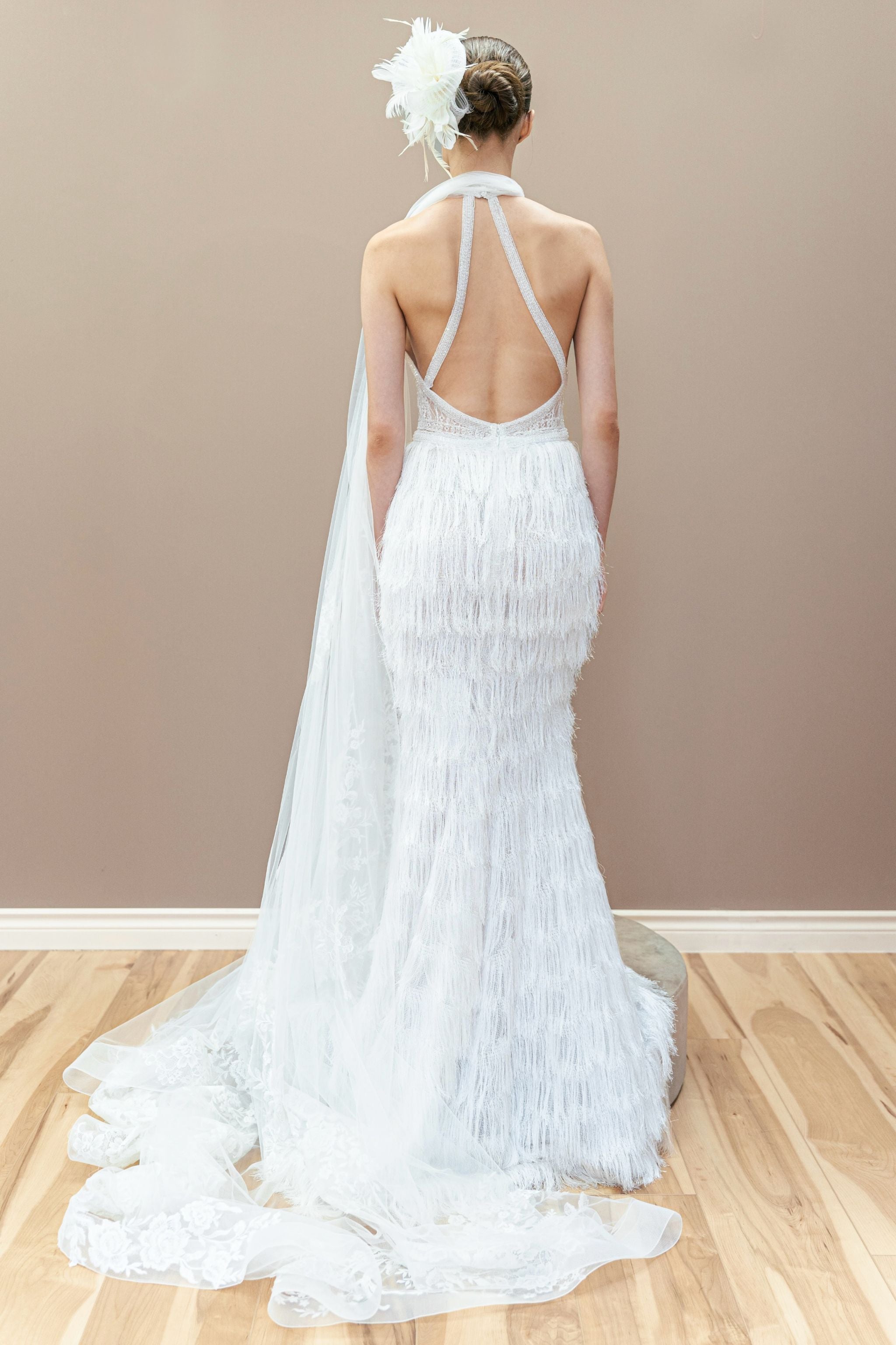 Back view of the modern couture wedding gown, showcasing the low back and fitted silhouette with fringe detailing.