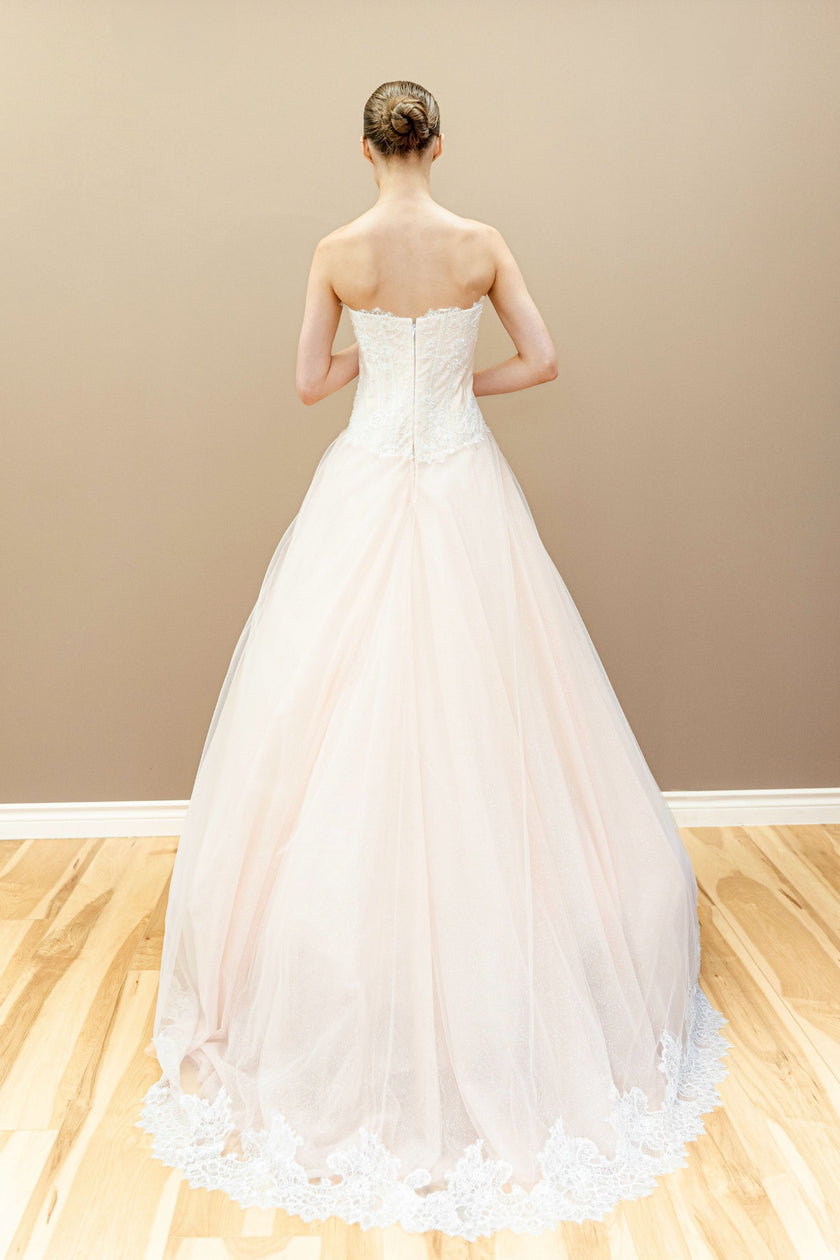Peach bridal gown with lace-up corset back and embroidered floral appliqué.