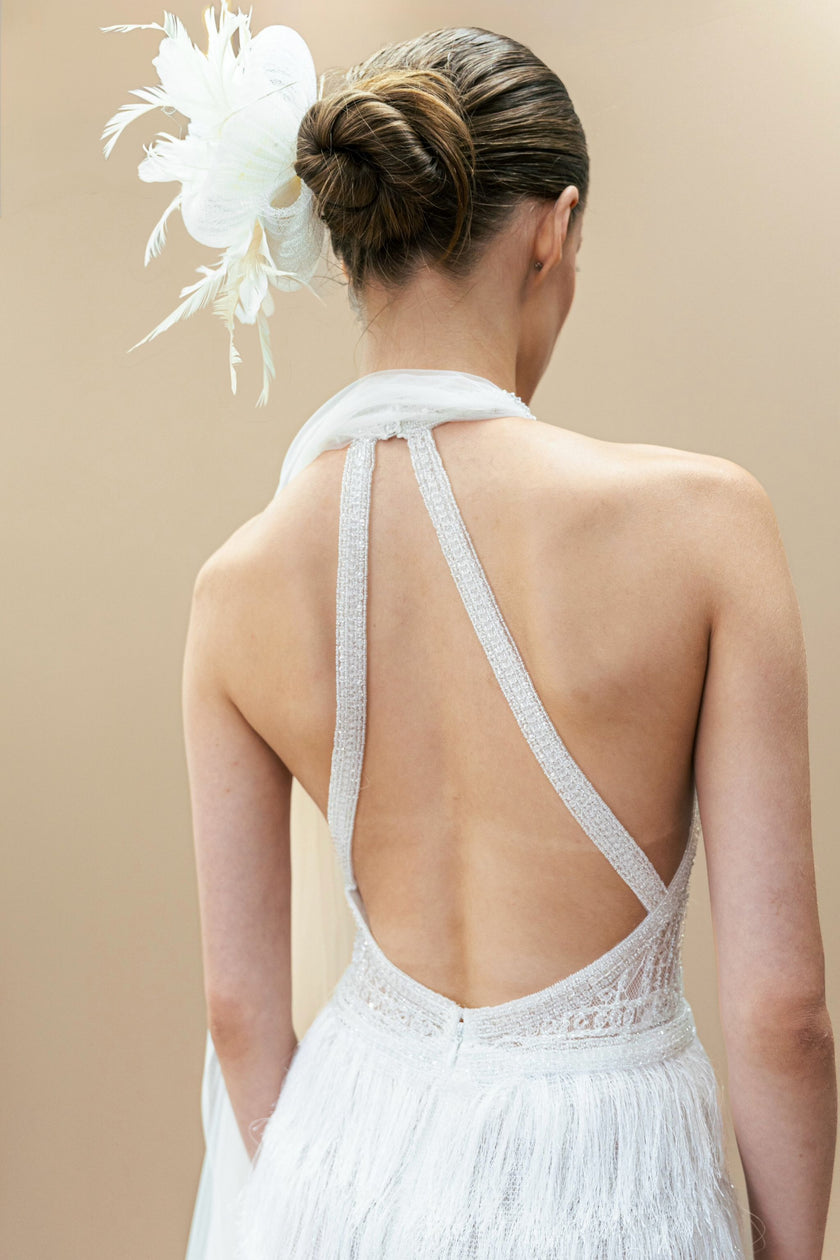 Back view of modern couture wedding gown with halter neckline and lace bodice.