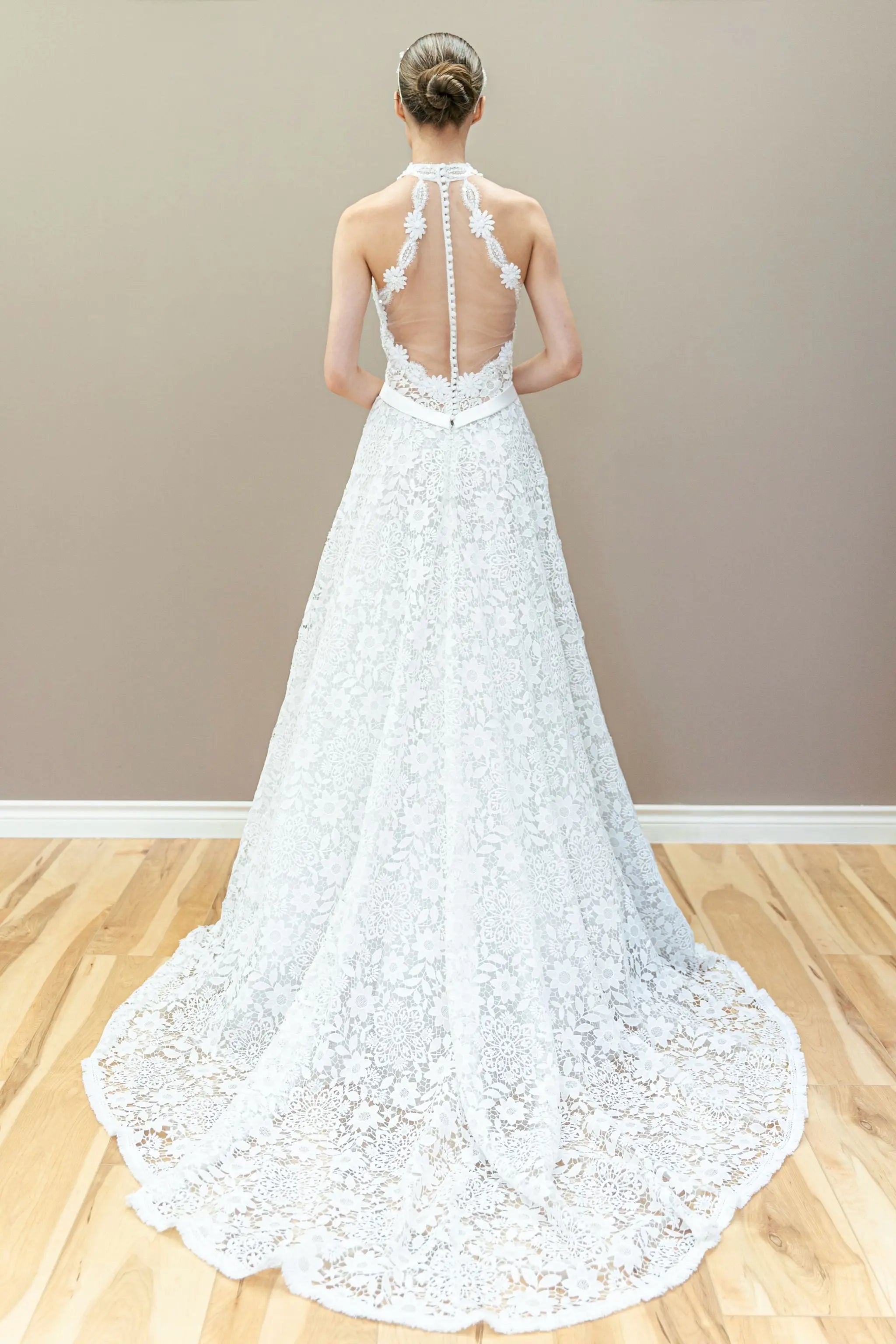 Back view of elegant halter lace wedding gown featuring illusion bodice and graceful A-line flow.
