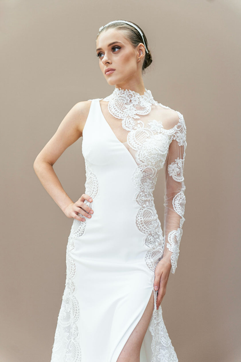 One-shoulder couture wedding gown with illusion lace sleeve and high side slit.