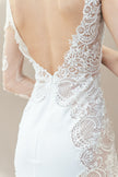 Close-up back view of illusion lace sleeve and floral appliqué on one-shoulder bridal gown.