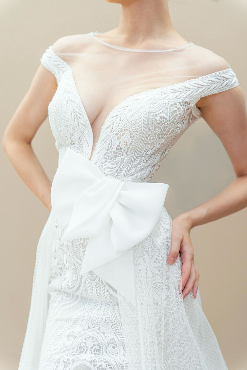 Close-up of the oversized satin bow on the elegant lace mermaid wedding gown.