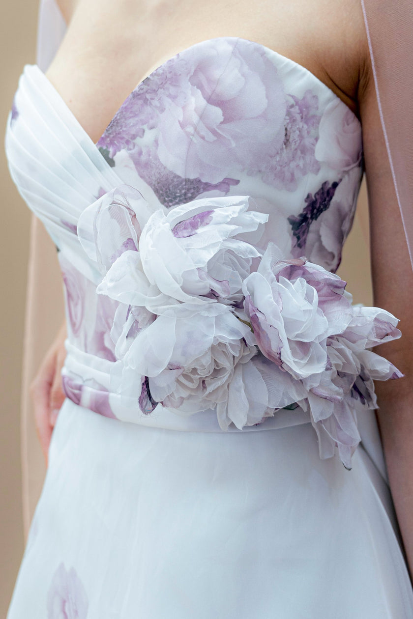 Close-up view of the floral embroidery and draped folds on the strapless sweetheart bodice of the wedding gown.
